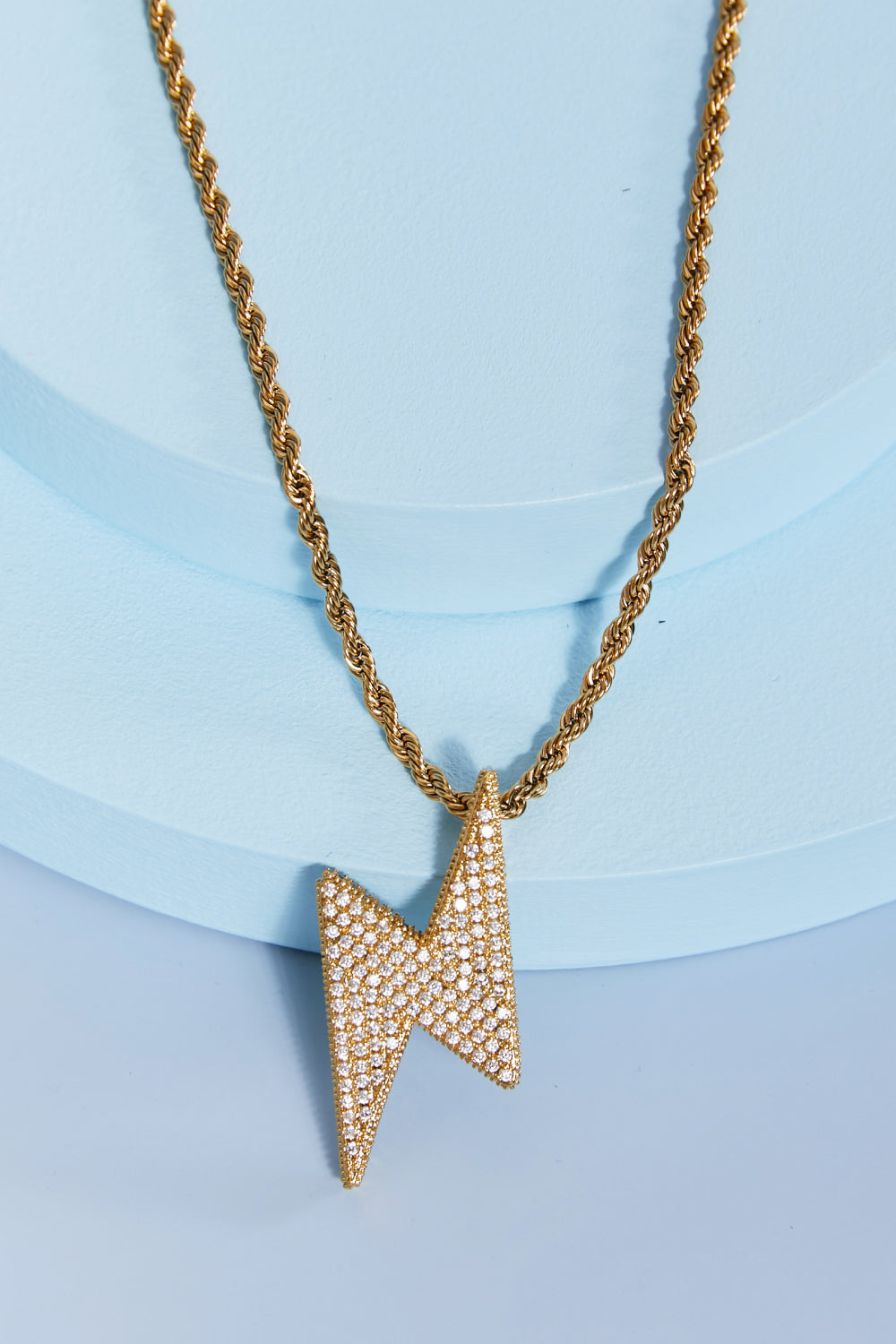 Lightning pendant necklace with a twisted chain, crafted from brass, stainless steel, and cubic zirconia for a sparkling touch.
