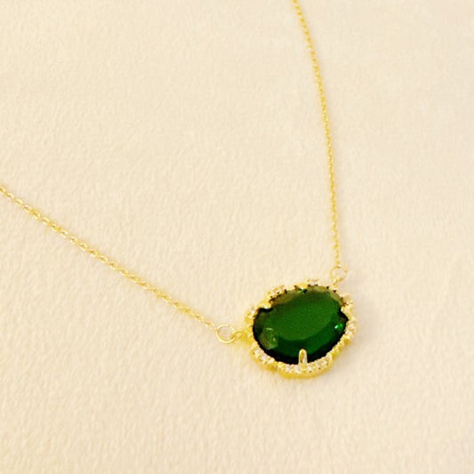 Clustered Glass Jewel Necklace with emerald green glass stone and gold chain, elegant flat lay.