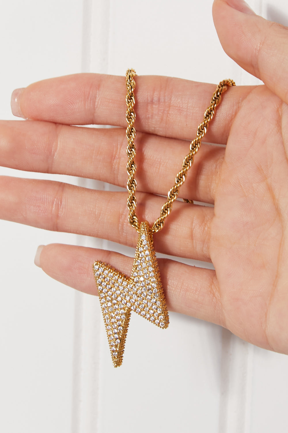 Lightning pendant necklace with a twisted chain, crafted from brass, stainless steel, and cubic zirconia for a sparkling touch.