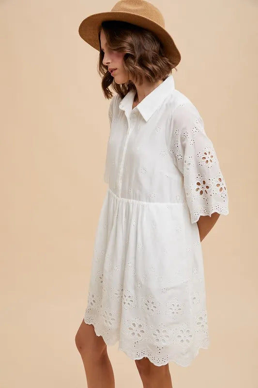 Side view of the Kiaan Embroidered Mini Dress in ivory, highlighting scalloped edge and embroidered eyelet detail.