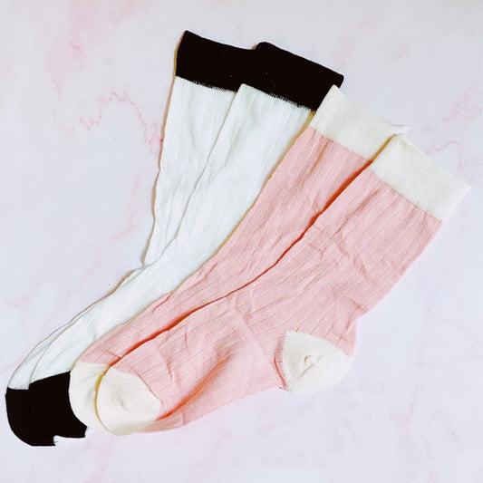 Flat lay of Silky Jacquard Socks set with white pair with black trim and pink pair with white trim.