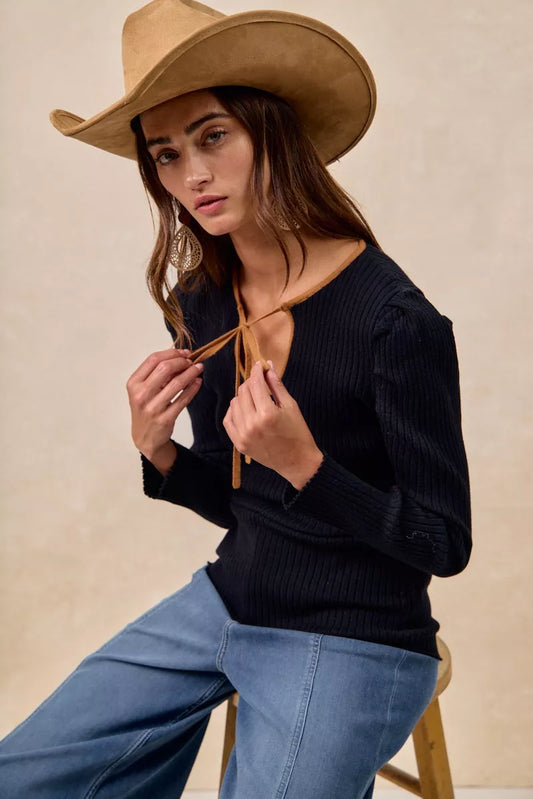 Side angle showing fitted ribbed knit and puffed sleeve shoulder detail.