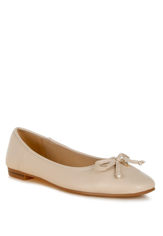 Beige vegan leather ballerinas with bow detail, cushioned insoles, and round closed toe for stylish all-day comfort.