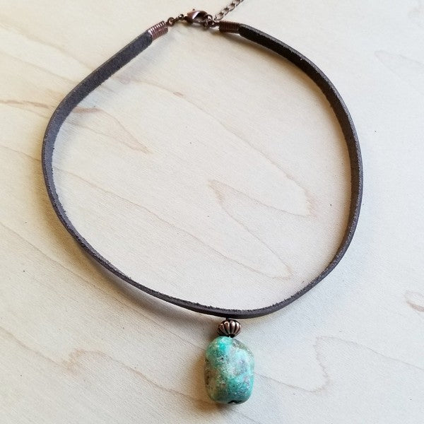 Flat lay of African Turquoise Leather Choker with genuine leather band and bold turquoise stone centerpiece, handcrafted boho style.