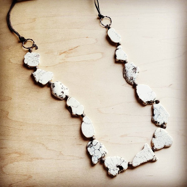 Chunky white turquoise slab necklace featuring copper hoops and adjustable leather fringe closure in boho design.
