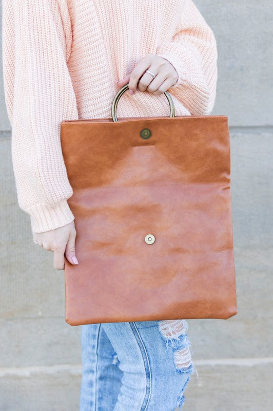 Safara Fold-Over Clutch unfolded to display magnetic closure and smooth vegan leather exterior.