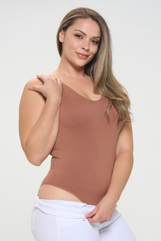 Plus-size woman wearing a Mocha seamless V-neck tank bodysuit, displaying smooth, fitted silhouette and reversible neckline.