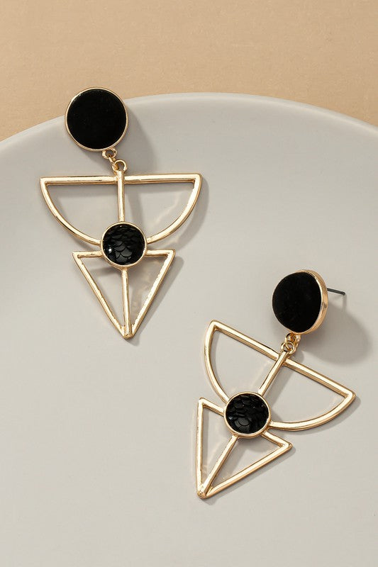 Gold earrings feature a velvet stud, geometric cutout design, and a textured black stone embedded in the cutout. They are 2.5 inches long.