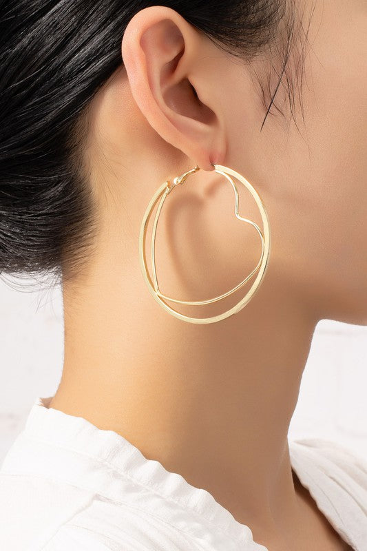 Woman wearing Circle & Heart Hoop Earrings in shiny gold, showcasing playful heart-in-circle design.