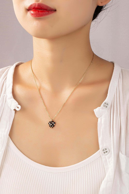 Woman wearing the Mayley Checker Heart Pendant Necklace in black with a checkered heart charm.