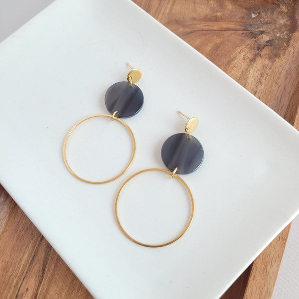 Flat lay close-up of Sadie Earrings showing black acrylic and gold charm.