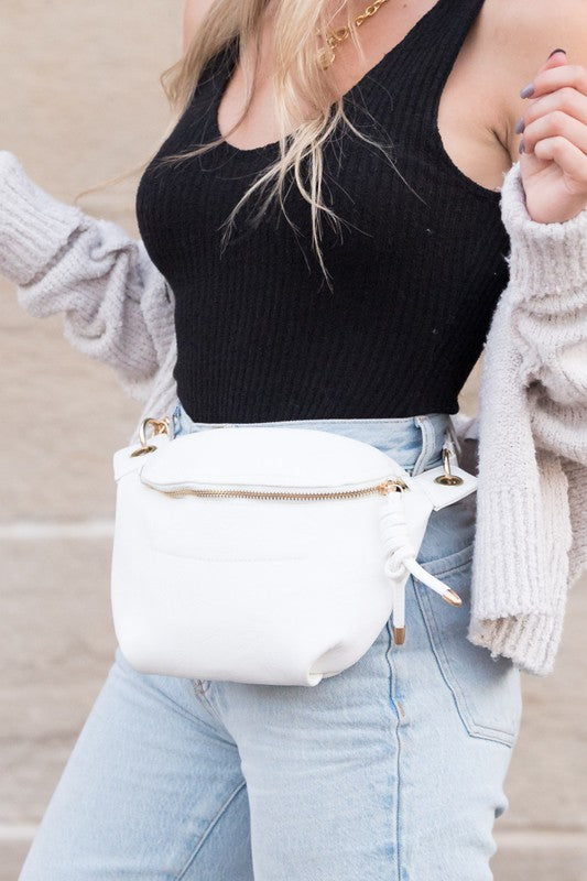 White Luxie Convertible Sling Belt Bag styled at waist with adjustable strap.