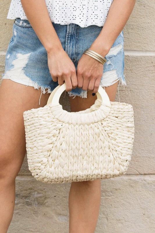 Bohemian straw bag with wood handle, perfect for casual or weekend outings.