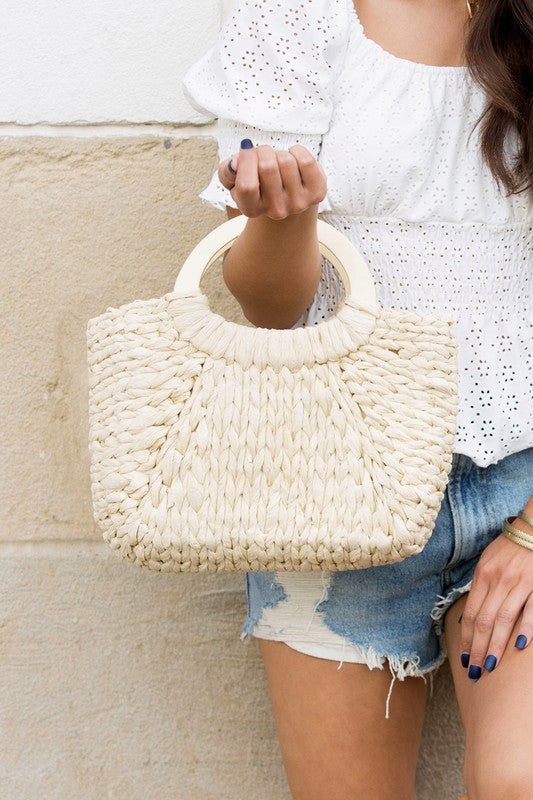 Natural straw woven tote with rustic wood handle and lightweight design.