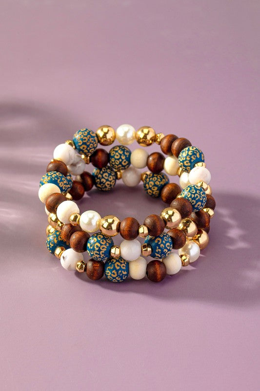 Livia Wood Carved Animal Print Bracelet Set with blue leopard wood beads, cream and brown accents, acrylic pearls, and CCB beads.