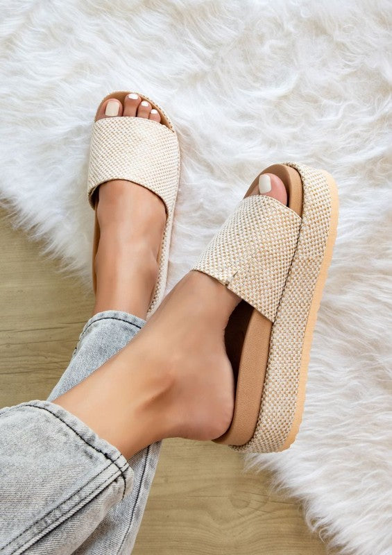 Woman wearing natural beige Tina Woven Flatform Sandals with 2-inch cushioned sole and slip-on woven strap.