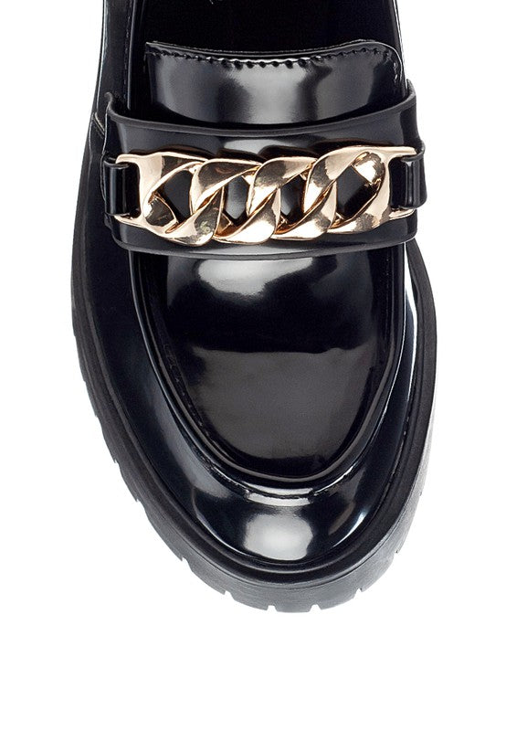 Sachs Block Heeled Chunky Loafers in Black close view of gold chain across vamp and glossy round toe.