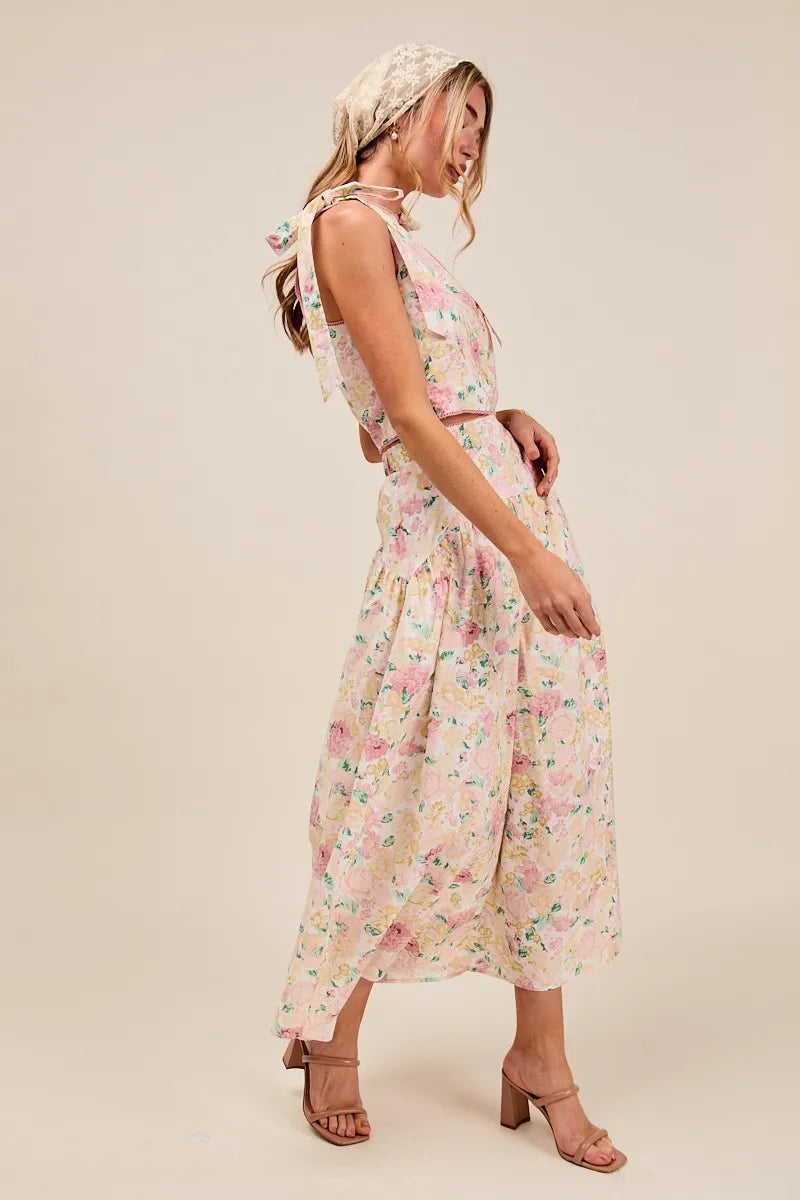 Full body side view of model in Soraya Floral Two-Piece Set with tiered maxi skirt and bow-tied shoulder detail.