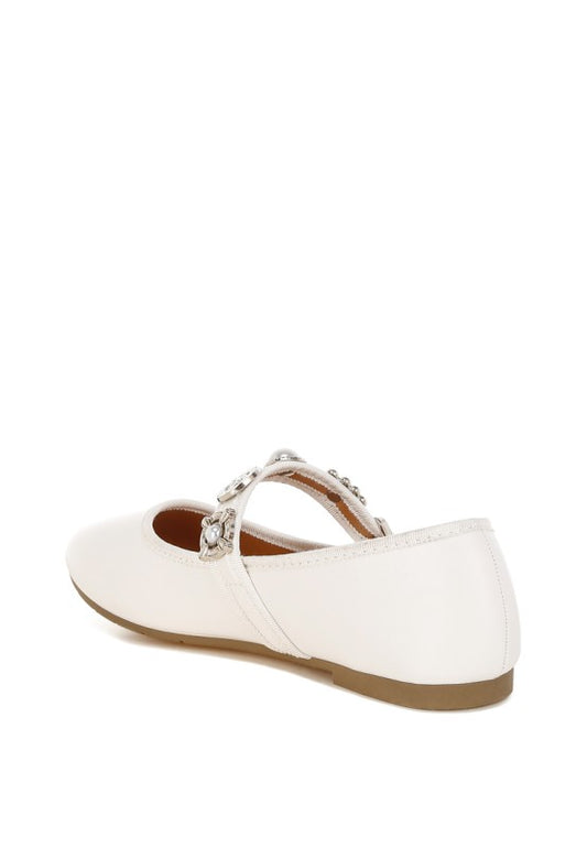Inside angle view of white Kavana Mary Jane Flats highlighting the buckle strap, pearl and rhinestone charms, and back heel construction.