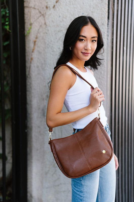 Chocolate vegan leather Marissa bag with gold details, slim profile, and short chain strap.