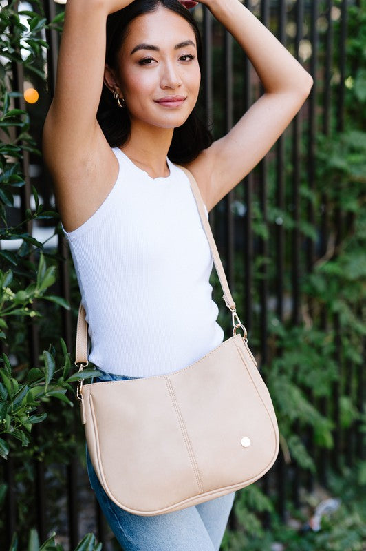 Biscuit Marissa crossbody bag with gold hardware, detachable chain strap, and soft vegan leather.