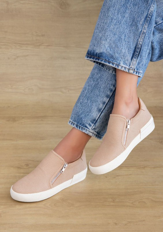 Nude slip-on sneakers with a round toe design and side zippers.