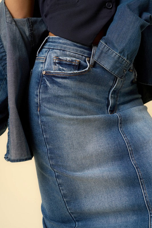 Close-up of dark wash denim fabric and stitching on maxi skirt for texture detail.