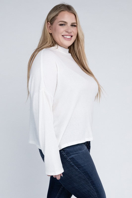 Plus size model wearing Raya Curvy Plus Drop Shoulder Top in off white with mock neck, side view.