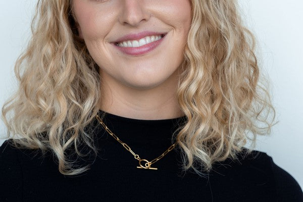 Woman wearing Nissa Gold Paperclip Chain Necklace, 16-inch, 18K gold-plated, toggle clasp, elegant and tarnish-resistant.