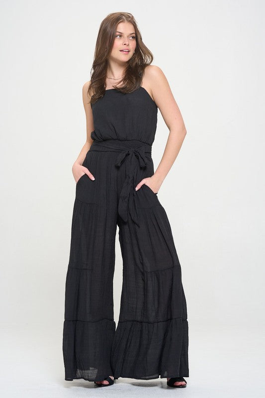 Front view of black Chara Curvy Plus Tiered Jumpsuit with square neckline and ruffled straps.