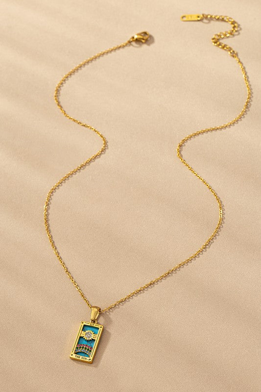 Tarot Card Sun Pendant Necklace with turquoise background and rhinestone rainbow on gold-tone chain.