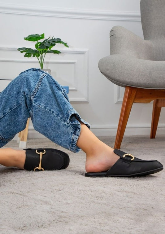 Sleek black vegan leather mules with gold bit accent, low heel, and slip-on comfort for casual or dressy outfits.