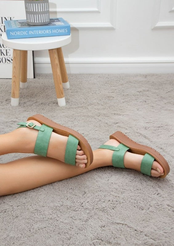 Side view of Vanya green flatform sandals with open toe and slingback strap.