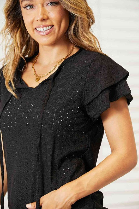 Black flutter sleeve Tami Eyelet Tie-Neck Top with chic tie detail and breathable, non-stretch polyester fabric.