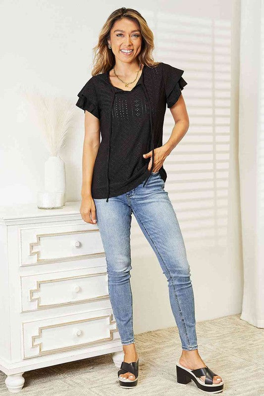 Eyelet-detailed Tami black tie-neck blouse with flutter sleeves, lightweight fabric, and regular fit style.