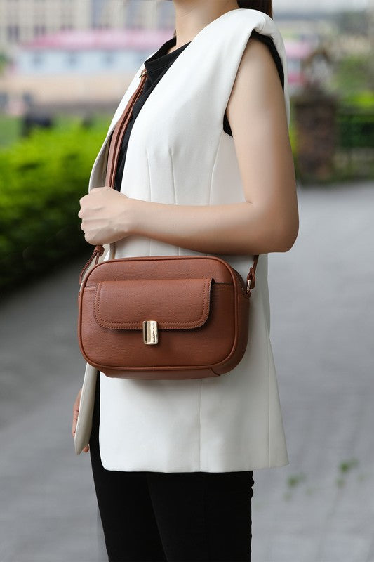 Woman holding brown Michaela Vegan Leather Shoulder Bag with gold-tone hardware.