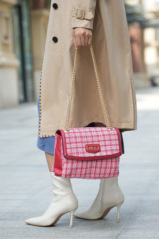 Woman holding gold-tone chain strap of red Mackenzie Tweed Shoulder Bag, showing tweed fabric and flap closure.