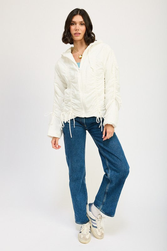 Model full body in ivory Candes Ruched Puff Jacket and jeans