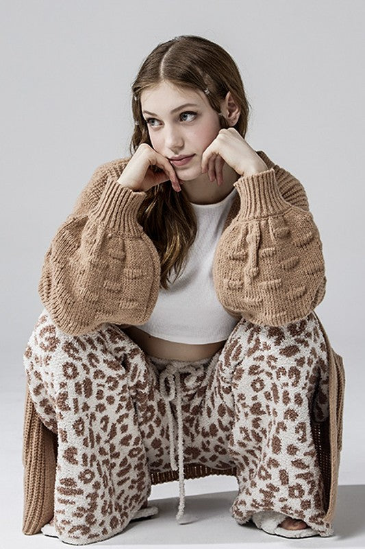Aleah Plus Size Leopard Lounge Pants in cream with camel spots, crouched casual lifestyle pose