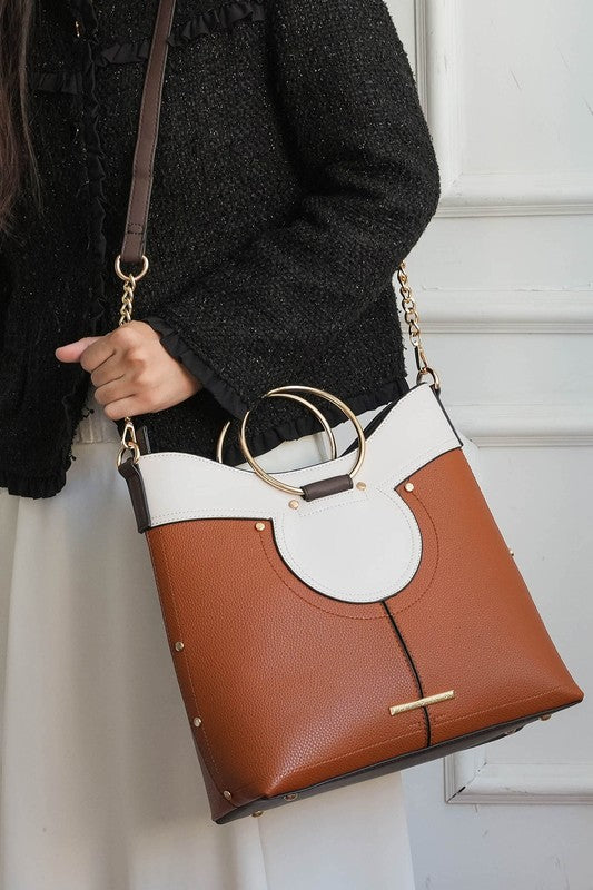 Woman wearing cognac Kylie satchel over shoulder with gold-tone hardware.