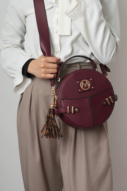 Woman wearing wine MKF Gayle Crossbody Bag with adjustable strap, crossbody style.