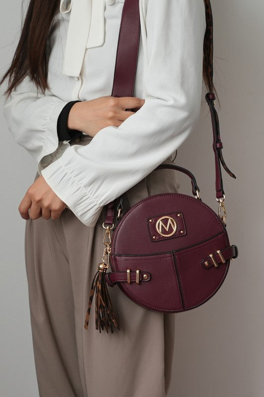 Woman wearing wine MKF Gayle Crossbody Bag over shoulder with gold-tone hardware visible.