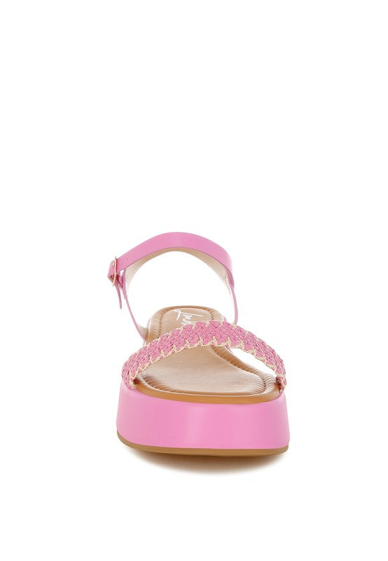 Front view of pink woven raffia flatform sandals with open toe, dual-strap design, and cushioned footbed.