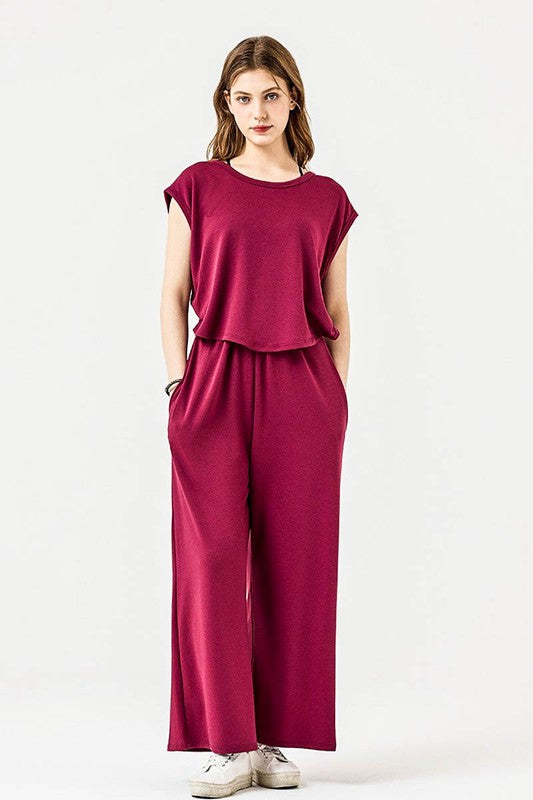 Kora Wide Leg Jumpsuit in wine with relaxed wide-leg silhouette and pockets.