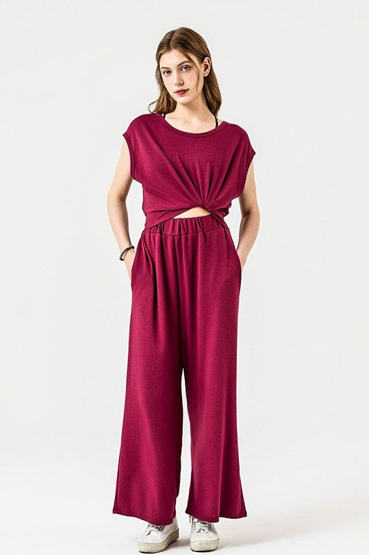 Front view of Kora Wide Leg Jumpsuit in wine red with twist-front detail.