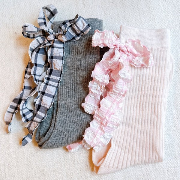Folded grey and pink Plaid Ruffle Bow Socks set highlighting plaid bow detail.