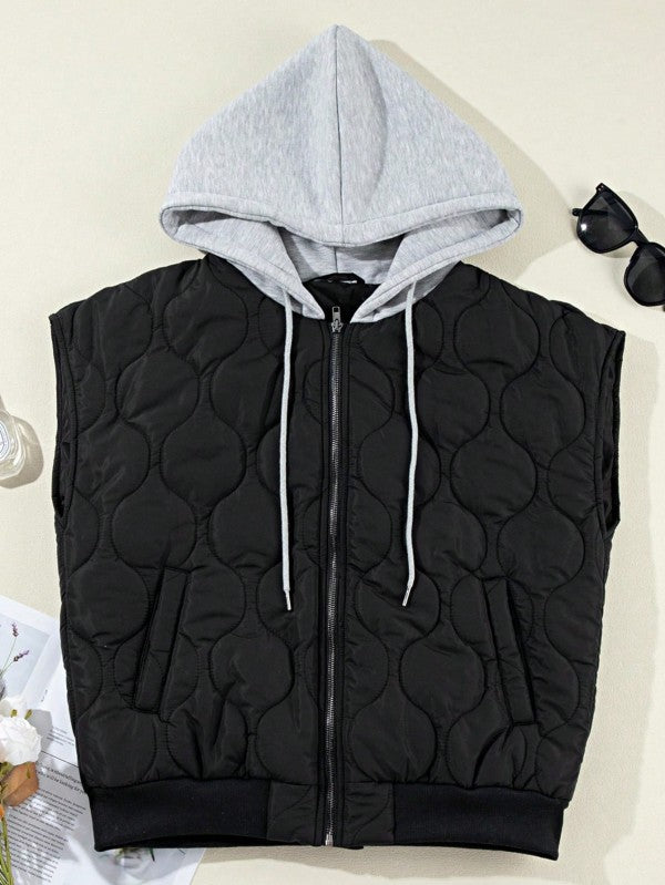 Flat lay of the black Meara Oversized Puffer Vest highlighting the quilted texture, gray hood, and front pockets.