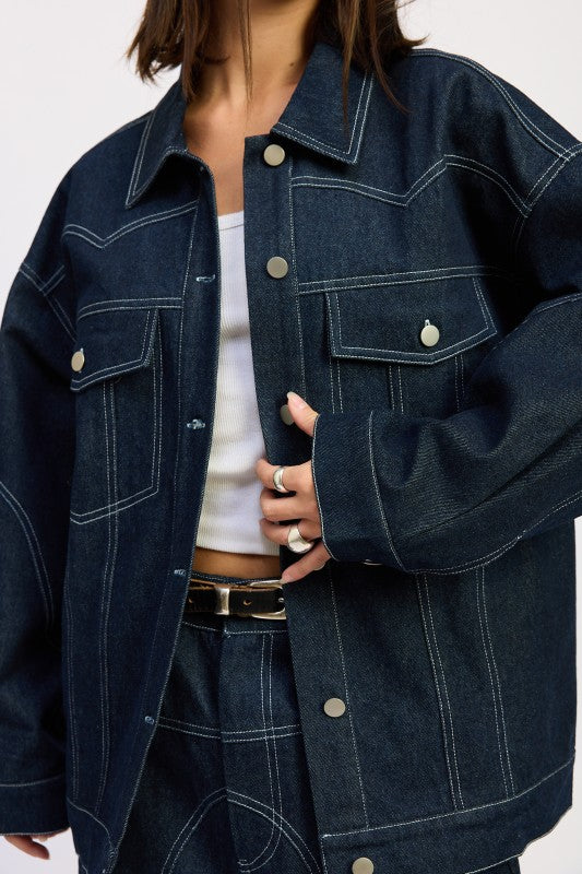 Close-up of Brin Oversized Denim Jacket showing snap buttons and pocket stitching detail.