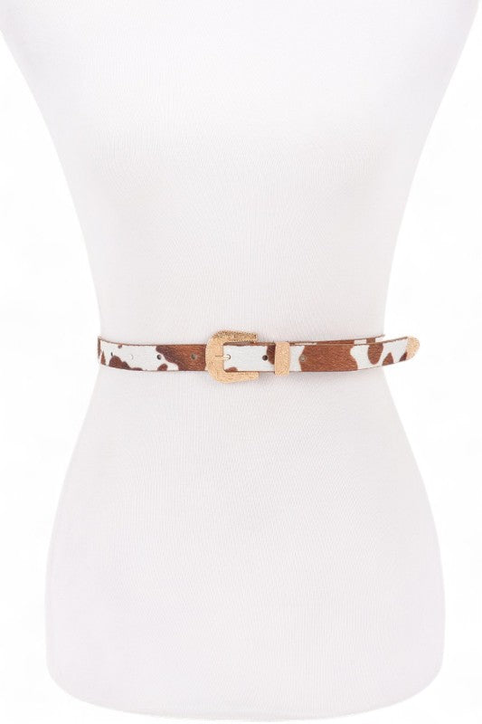Cowhide Dhara Skinny Belt front view with bold animal print and gold buckle accent.