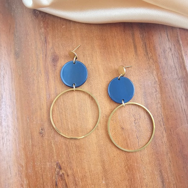 Close-up flat lay of navy acrylic Sadie Earrings highlighting gold-plated charm.